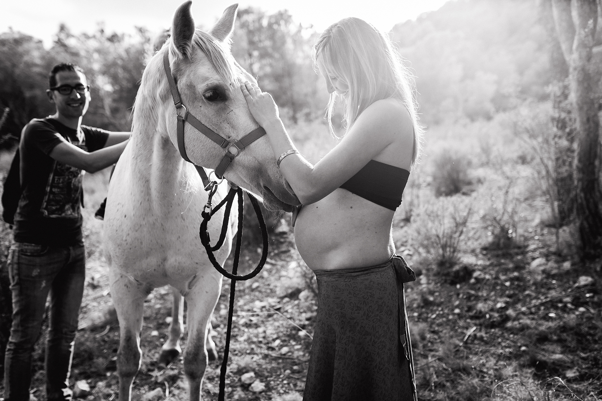 Mujer embarazada junto a su caballo en un entorno natural
